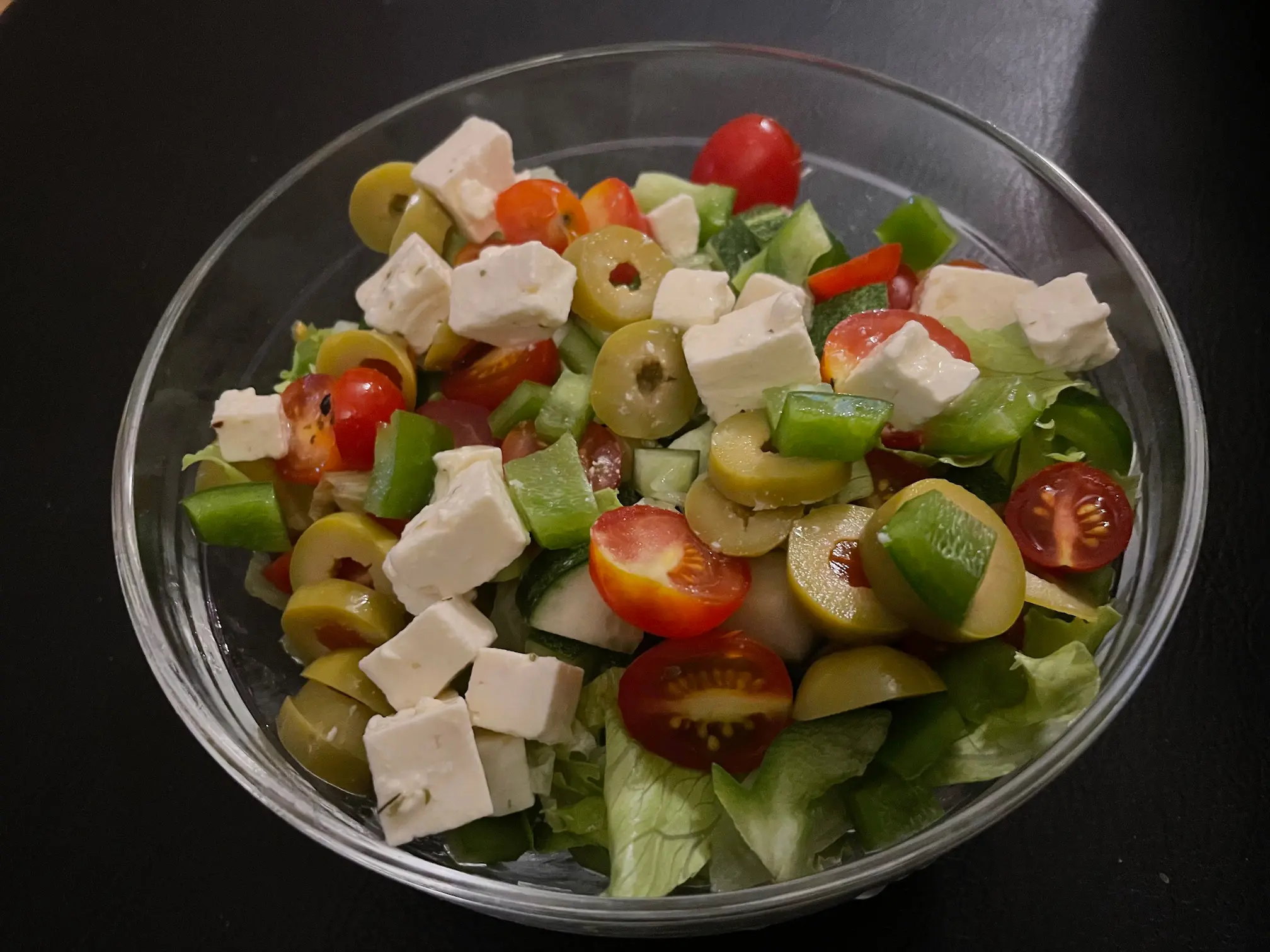 Fresh homemade salad with goat cheese, tomatoes, cucumber, peppers, and olives at De Klomp Homestead