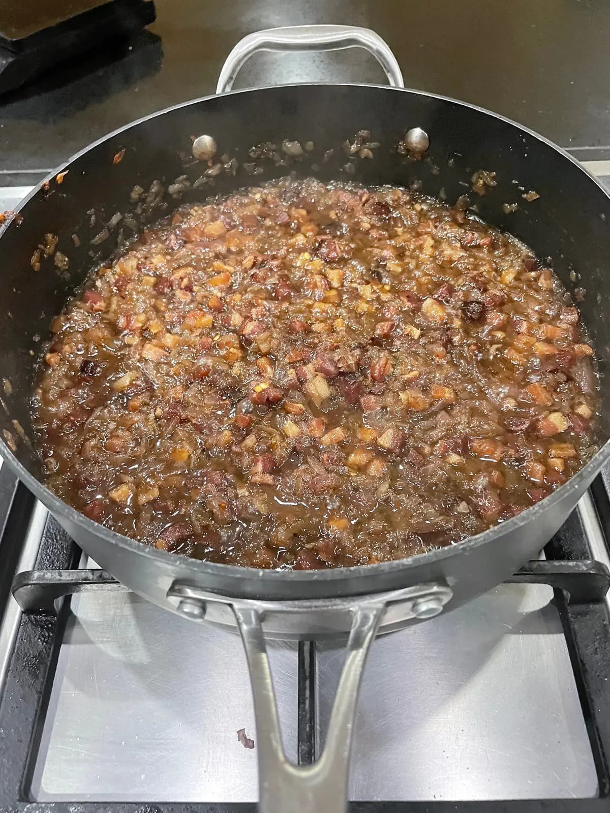 Homemade bacon jam simmering as the onions, bacon and liquid slowly reduce