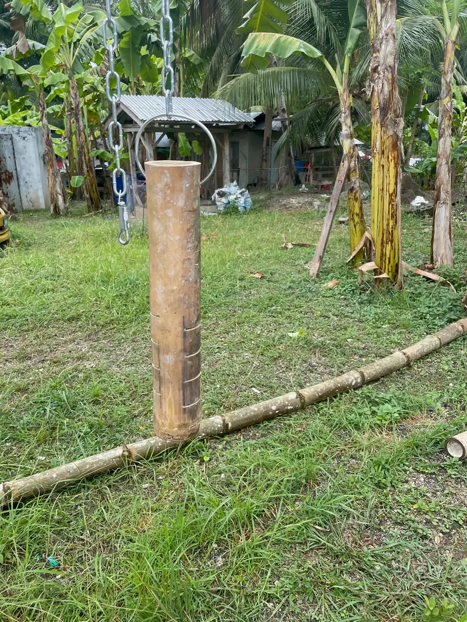 Homemade bamboo salt lick holder hanging from a stainless-steel chain at De Klomp Homestead